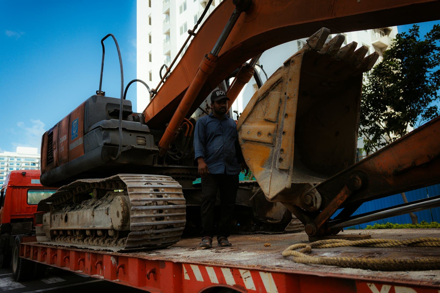 Pelle sur chenilles chargée sur un porte-engin, prête au transport